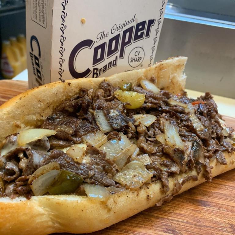 Cheesesteak loaded with onions, peppers, and Cooper Sharp