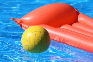 yellow volleyball and orange pool float in swimming pool
