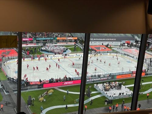 players from the New Jersey devils and the Philadelphia flyers skating on an ice rink