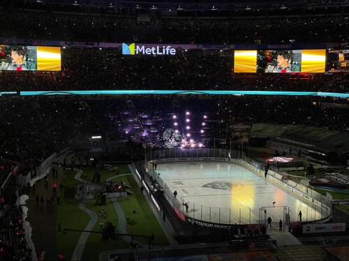 The Jonas Brothers on stage in the stadium with the lights dimmed